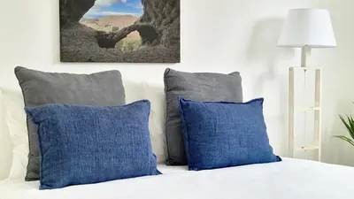 a bed with blue and gray pillows on it at Casa do Pico by Casas dos Lebre in Porto Santo