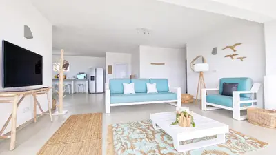a living room with blue chairs and a tv at Casa do Pico by Casas dos Lebre in Porto Santo