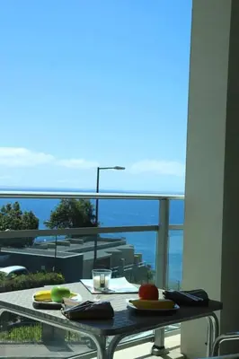 a table with plates of food on top of a balcony at GuestReady - Rodamar Apartment in Funchal