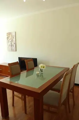 a dining room table with a vase of flowers on it at GuestReady - Rodamar Apartment in Funchal