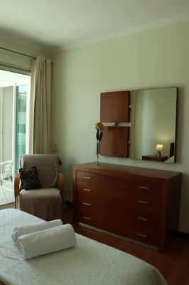 a bedroom with a dresser and a mirror at GuestReady - Rodamar Apartment in Funchal