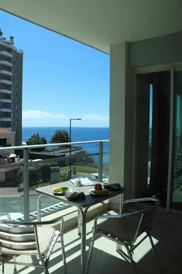 a table and chairs on a balcony with a view of the ocean at GuestReady - Rodamar Apartment in Funchal
