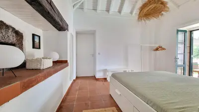a bedroom with white walls and a bed in a room at Nossa Casa by Casas dos Lebre in Porto Santo