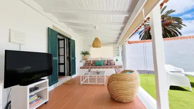 a living room with a tv and a balcony at Nossa Casa by Casas dos Lebre in Porto Santo