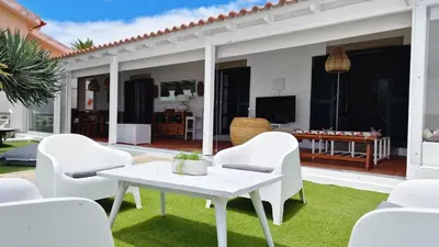 a patio with white chairs and a table at Nossa Casa by Casas dos Lebre in Porto Santo