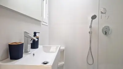 a white bathroom with a sink and a shower at Nossa Casa by Casas dos Lebre in Porto Santo