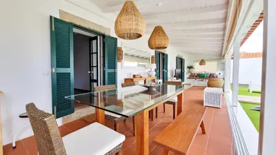 a dining room with a glass table and chairs at Nossa Casa by Casas dos Lebre in Porto Santo