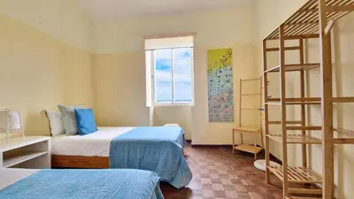 a bedroom with two beds and a ladder at Casa da Ponta by Casas dos Lebre in Porto Santo