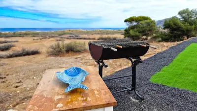 a grill and a blue hat sitting on a wooden bench at Casa da Ponta by Casas dos Lebre in Porto Santo