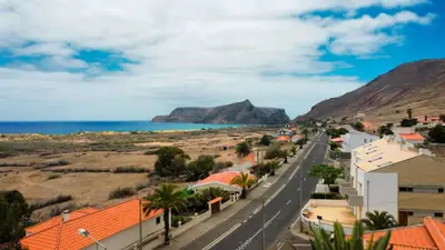 a street in a town with mountains and the ocean at Casa da Ponta by Casas dos Lebre in Porto Santo