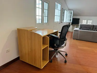 an office with a desk and a chair and a couch at Arco Apartment in Arco da Calheta