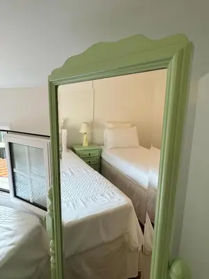 a mirror in a bedroom with two beds at Arco Apartment in Arco da Calheta