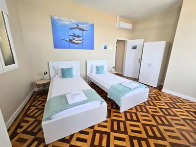 a room with two beds and a painting on the wall at A ver o mar rooms - Santa Cruz city center in Santa Cruz