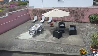 a table and chairs and an umbrella on a patio at A ver o mar rooms - Santa Cruz city center in Santa Cruz