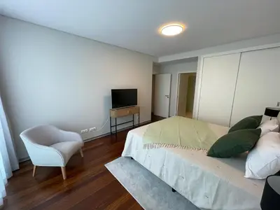 a bedroom with a bed and a chair and a television at Funchal Next Corner in Funchal