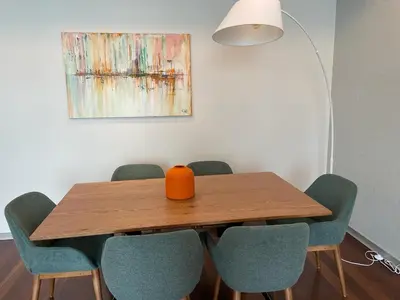 a dining room table with chairs and a vase on it at Funchal Next Corner in Funchal
