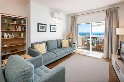 a building with a balcony with a table and an umbrella at Seascape - Escape to the seaside in Luz
