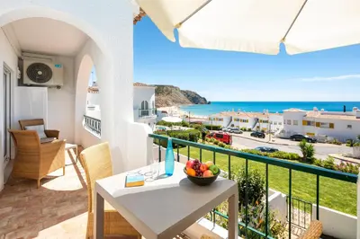 a balcony with a table and a view of the ocean at Seascape - Escape to the seaside in Luz