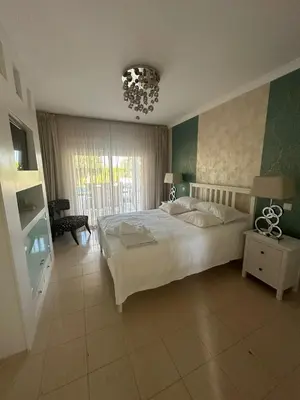 a bedroom with a large white bed and a chandelier at 3 Bedroom villa with a sea view completely private in Alagoas