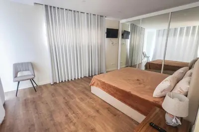 a small bedroom with a bed and a mirror at Casa do Beco do Barlavento in Vila Baleira
