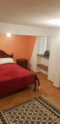 a bedroom with a red bed and a rug at Casa Gama in Ribeira da Janela