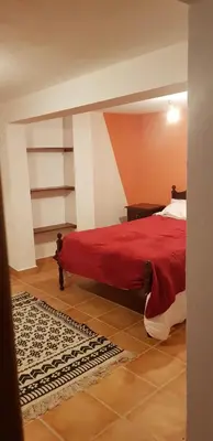 a bedroom with a bed with a red blanket at Casa Gama in Ribeira da Janela