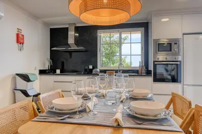 a kitchen with a table with wine glasses on it at Vale dos Amores, a Home in Madeira in Calheta