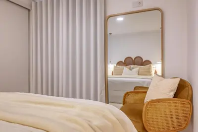 a mirror in a bedroom with two beds and a chair at Vale dos Amores, a Home in Madeira in Calheta