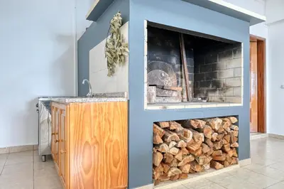a fireplace with a pile of fire wood at Vale dos Amores, a Home in Madeira in Calheta