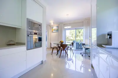 a kitchen with white walls and a table with chairs at Boa Vista - Golf View Villa in Lagos