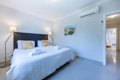a white bedroom with a large bed with towels on it at Boa Vista - Golf View Villa in Lagos