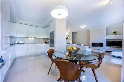 a kitchen and dining room with a glass table and chairs at Boa Vista - Golf View Villa in Lagos