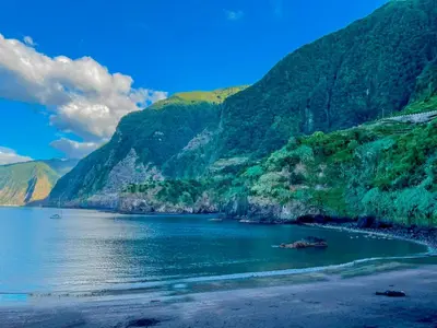 a body of water with a beach and mountains at Palheiro do Farrobo in Porto Moniz
