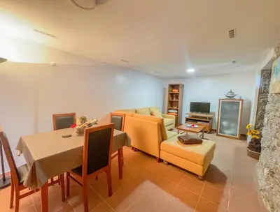 a living room with a couch and a table and chairs at Palheiro do Farrobo in Porto Moniz