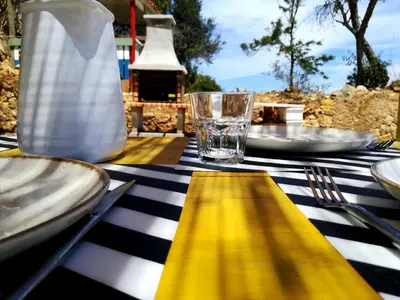 a black and white table with plates and a yellow napkin at Casa da Oliveira - Nice 2 bedrooms Bungalow in Lagos in Lagos