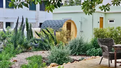a garden with a table and chairs in front of a building at Casa Pompilio in Sagres