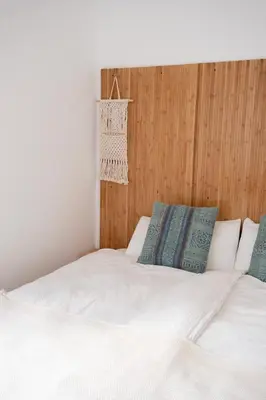 a bedroom with a white bed with blue pillows at Casa Pompilio in Sagres