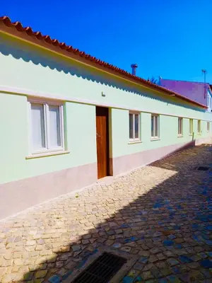 a white building with a cobblestone street next to it at Casa Pompilio in Sagres