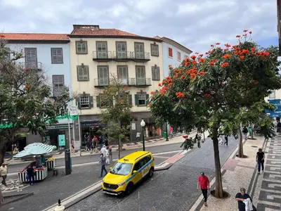 a yellow car parked on a street next to a building at RC Flats Funchal A in Funchal