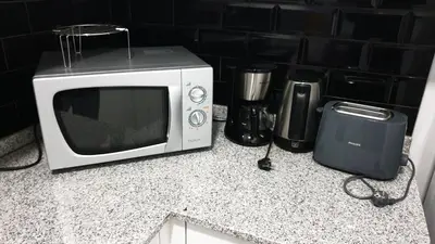 a microwave sitting on top of a counter at RC Flats Funchal A in Funchal