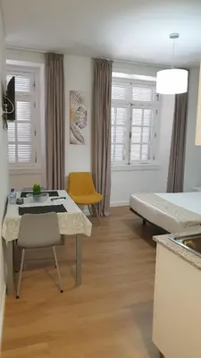 a room with a bed and a table and chairs at RC Flats Funchal A in Funchal