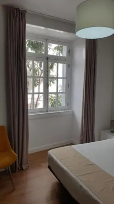 a bedroom with a bed and a large window at RC Flats Funchal A in Funchal