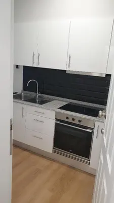 a white kitchen with a sink and a stove at RC Flats Funchal A in Funchal