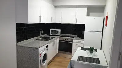 a kitchen with white cabinets and a white refrigerator at RC Fltas Funchal B in Funchal