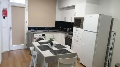 a kitchen with a table and a white refrigerator at RC Flats Funchal D in Funchal