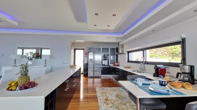 a large kitchen with a large island with a bowl of fruit at Azure Serenity Villa by LovelyStay in Santa Cruz