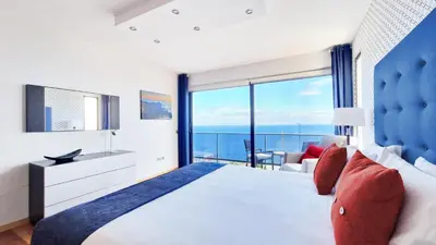 a bedroom with a large bed and a view of the ocean at Azure Serenity Villa by LovelyStay in Santa Cruz