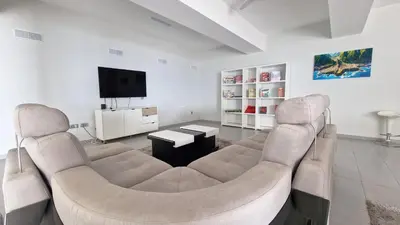 a living room with two couches and a flat screen tv at Azure Serenity Villa by LovelyStay in Santa Cruz