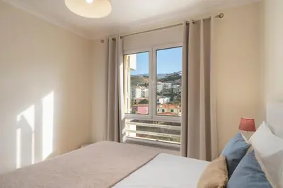a bedroom with a bed and a large window at Green Park by An Island Apart in Funchal