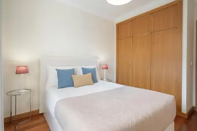a bedroom with a large white bed and a wooden cabinet at Green Park by An Island Apart in Funchal